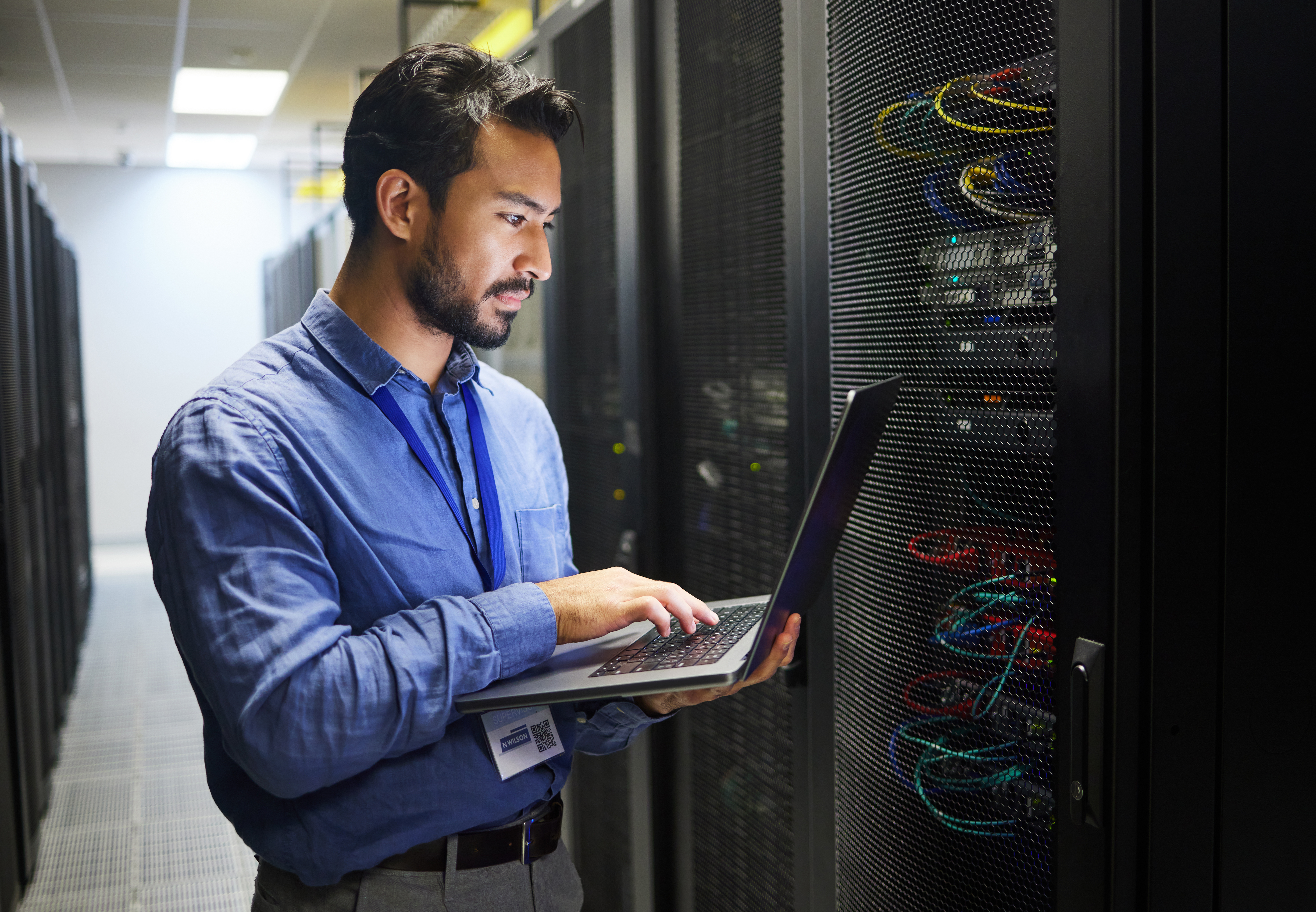 A Sourcepass Data Engineer is meticulously inspecting data centers.